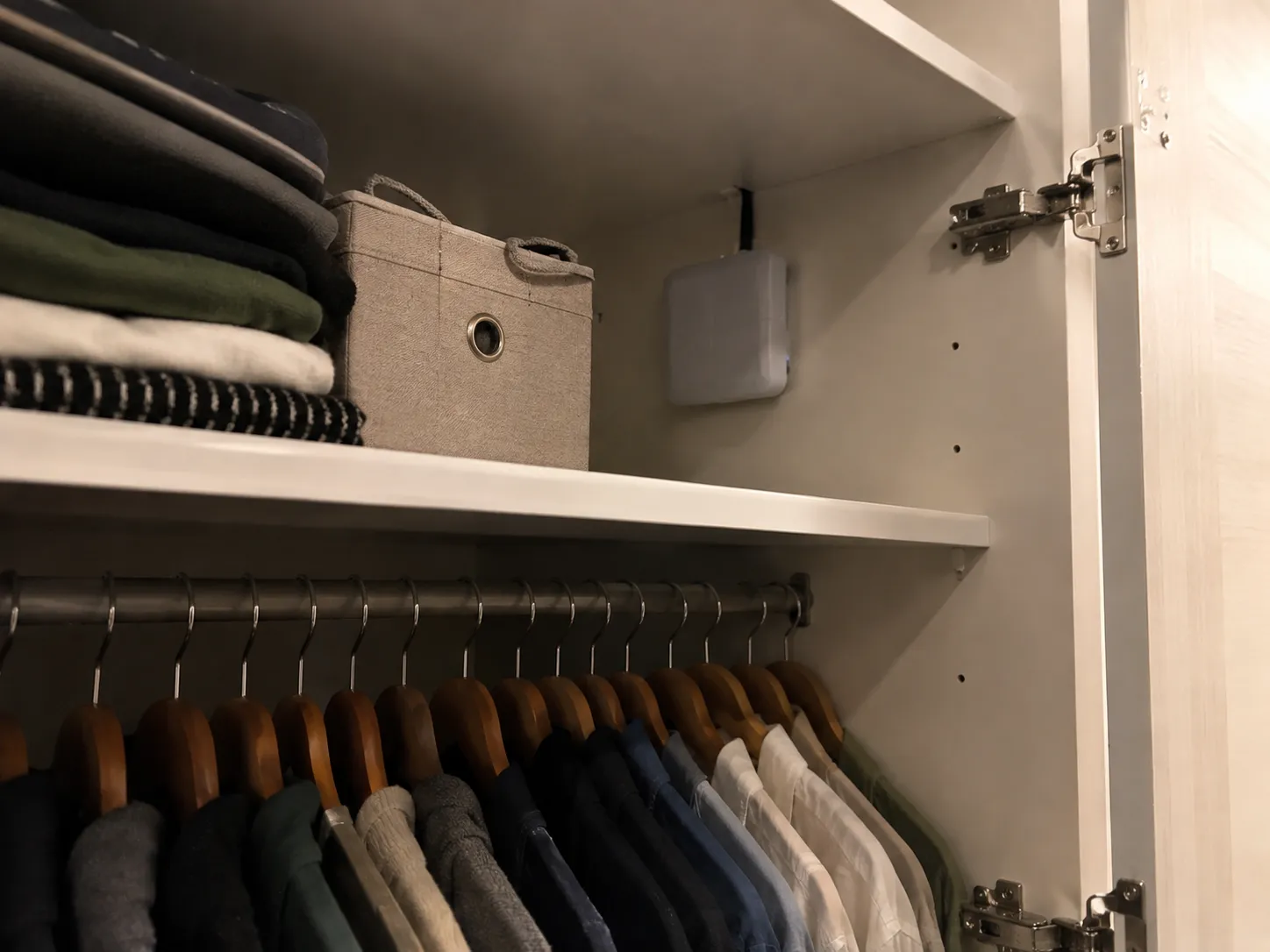 El lector de iCloset visto de más lejos, junto a una caja de tela, sobre la balda del armario.